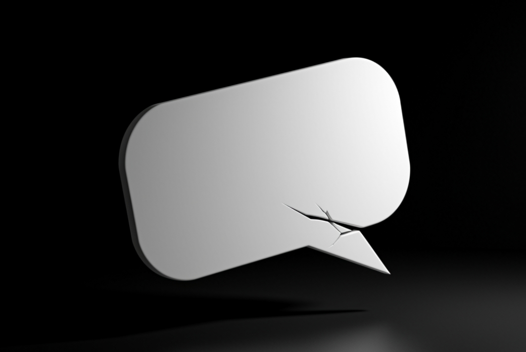 A speech bubble with a small crack in it, dark background, conceptual and moody